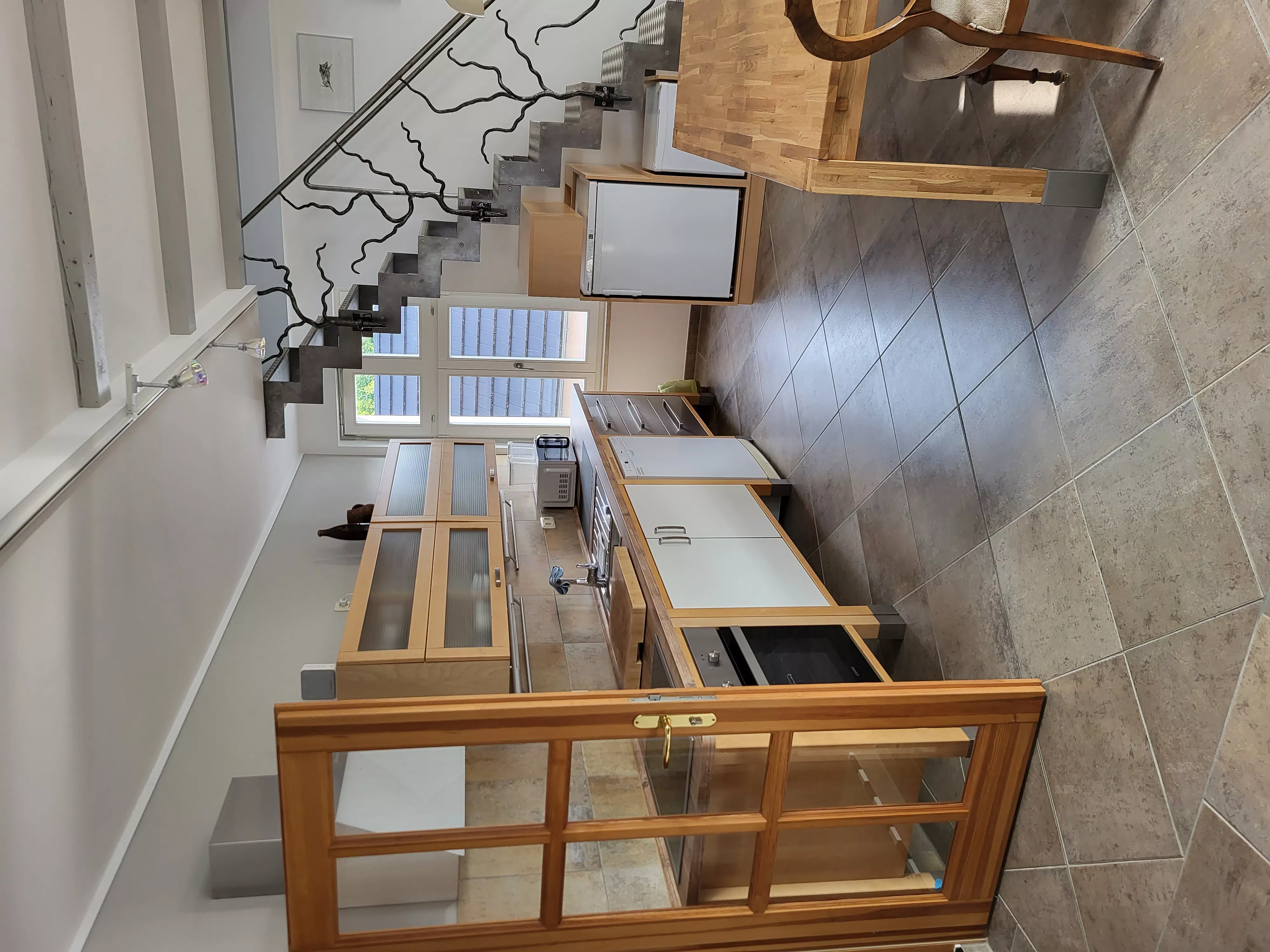 Voll ausgestattete Küche des Loft-Ferienapartments in Waren an der Müritz mit Ceranfeld, Backofen, Kühlschrank und hochwertigen Holzfronten