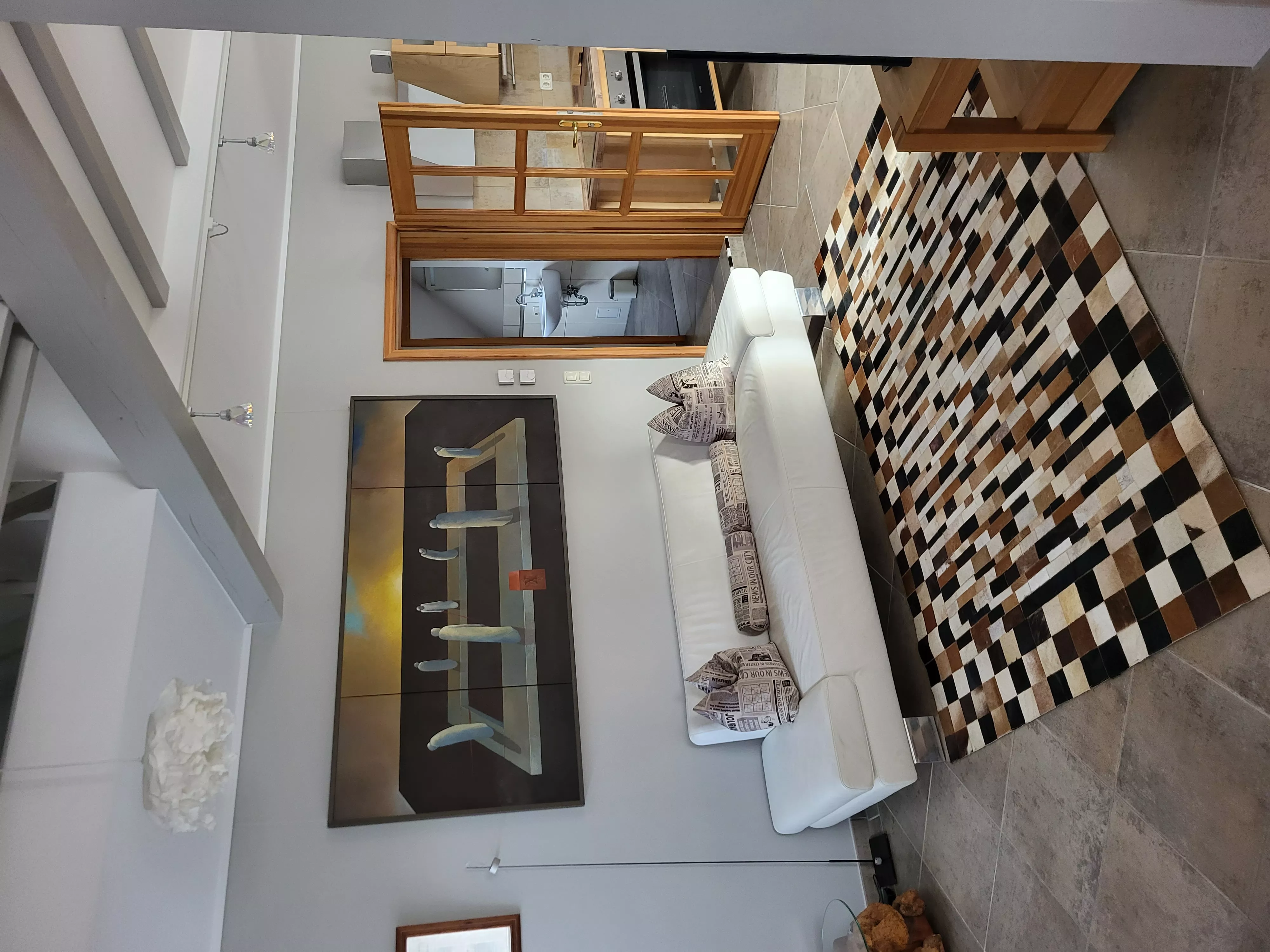 Zweite Perspektive des Wohnbereichs im Loft der Stadtvilla ValenTina mit Sofa, stilvollem Sideboard und Kunstobjekten – Ferienwohnung in Waren an der Müritz