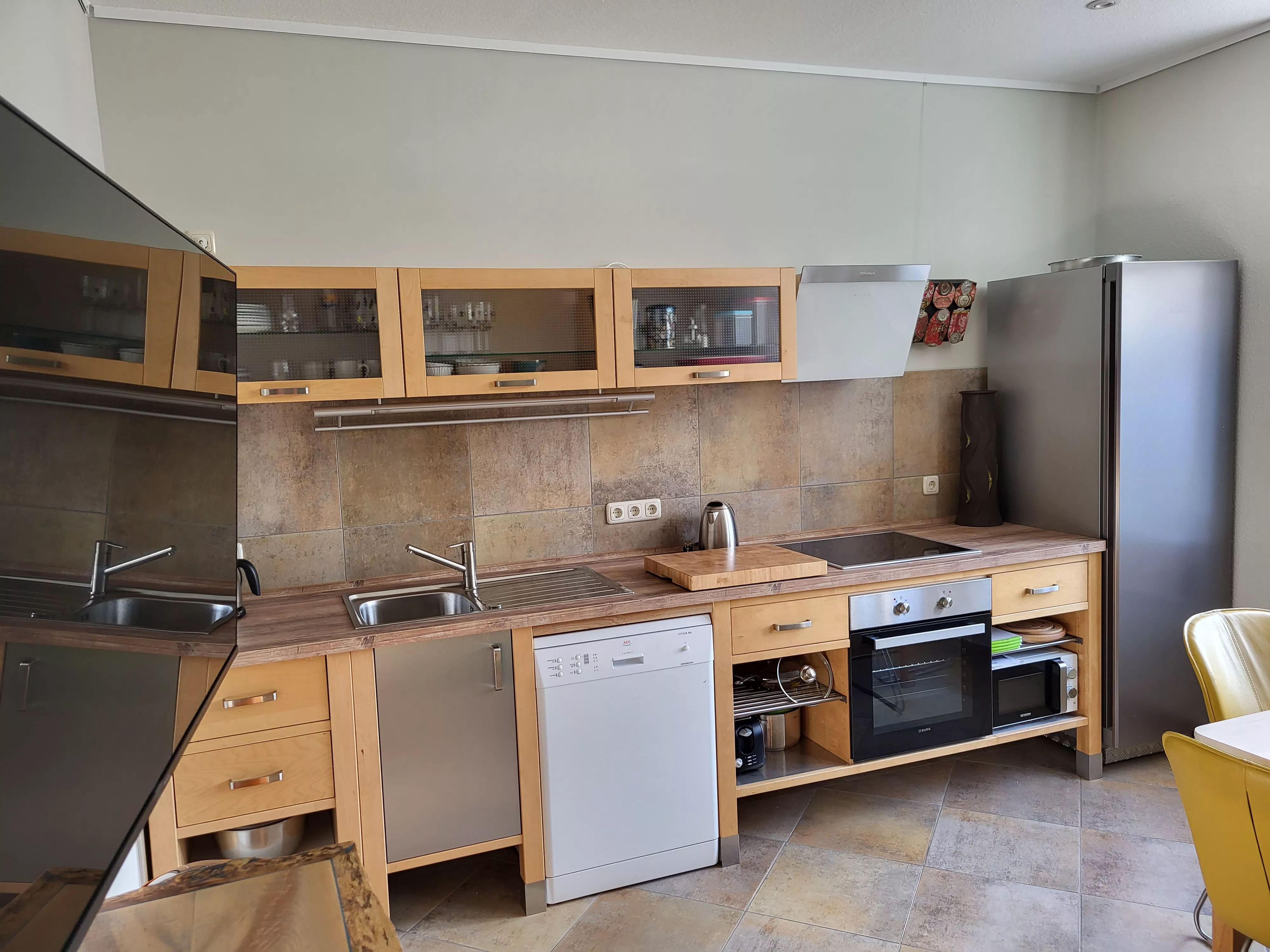 Voll ausgestattete Wohnküche der möblierten Wohnung in der Stadtvilla Neubrandenburg mit Holzmöbeln, Kochfeld, Backofen, Geschirrspüler und Kühlschrank